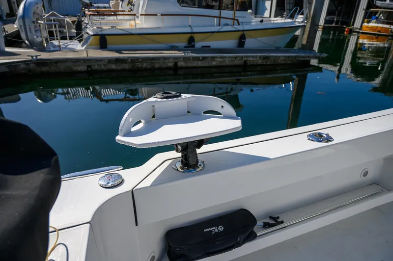 Slide: The Image of 2021 Ocean Sport 26/27 boat detail at marina, featuring a mounted accessory holder. - 13