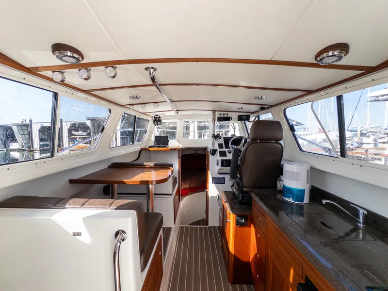 Slide: The Image of Interior of 2021 Ocean Sport 26/27 boat with seating, helm, and kitchenette. - 17