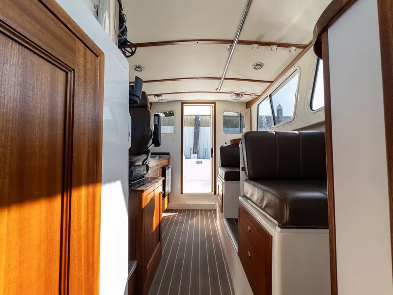 Slide: The Image of Interior of 2021 Ocean Sport 26/27 boat with wood accents and seating. - 18