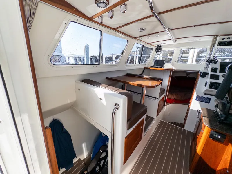 Slide: The Image of Interior of 2021 Ocean Sport 26/27 boat with seating, table, and helm station. - 19
