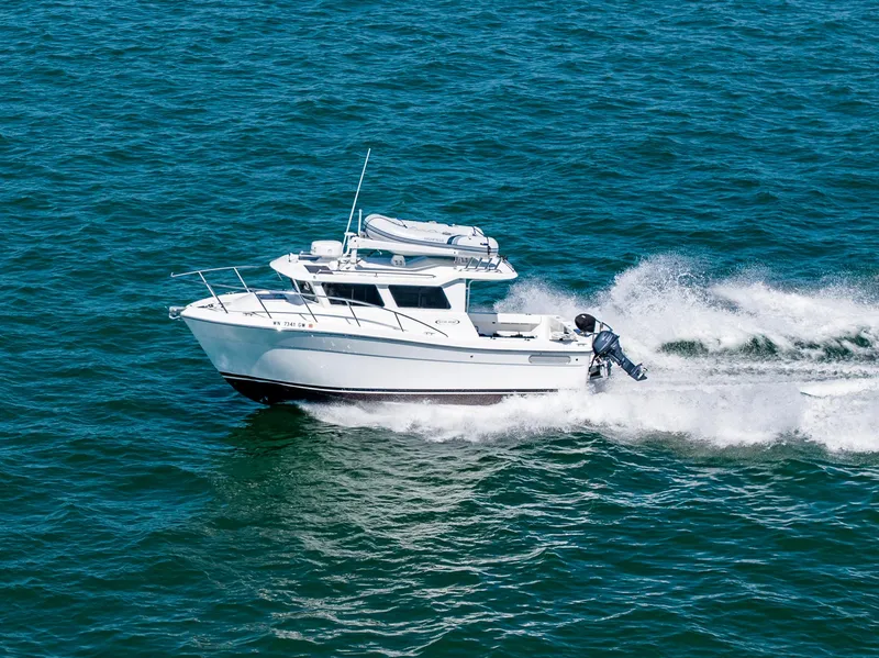 Slide: The Image of 2021 Ocean Sport 26/27 boat cruising on open water, creating waves. - 2