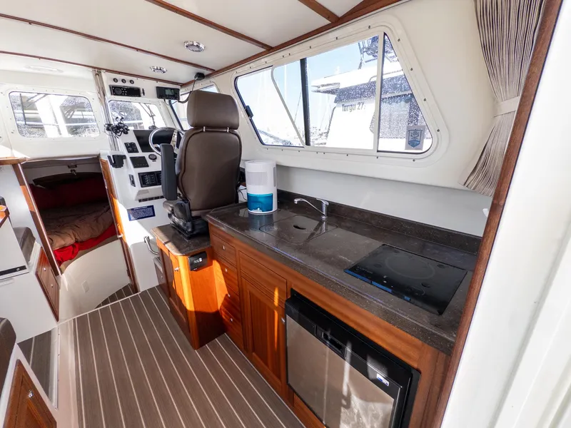 Slide: The Image of Interior of 2021 Ocean Sport 26/27 boat with kitchenette, helm, and sleeping area. - 22