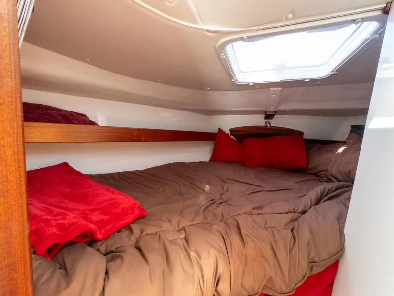 Slide: The Image of Cozy cabin interior of 2021 Ocean Sport 26/27 with red and brown bedding. - 23