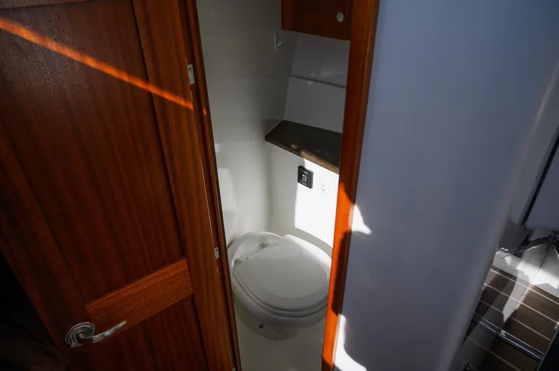 Slide: The Image of Compact bathroom in 2021 Ocean Sport 26/27 boat with wooden door and modern fixtures. - 24