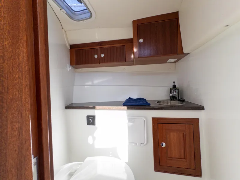 Slide: The Image of Interior of 2021 Ocean Sport 26/27 boat with wooden cabinets and compact sink. - 25