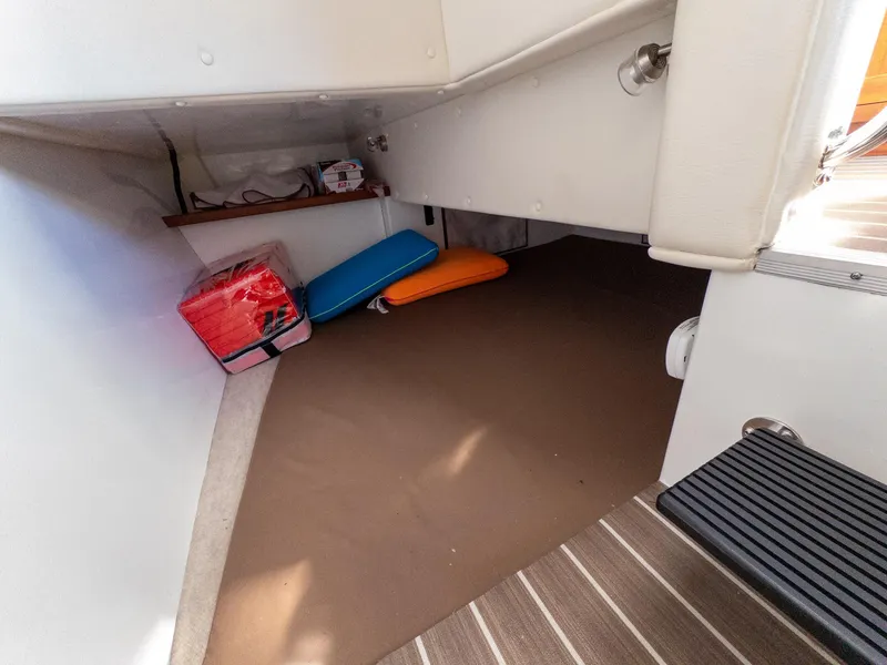 Slide: The Image of 2021 Ocean Sport 26/27 interior storage area with cushions and life jackets. - 26
