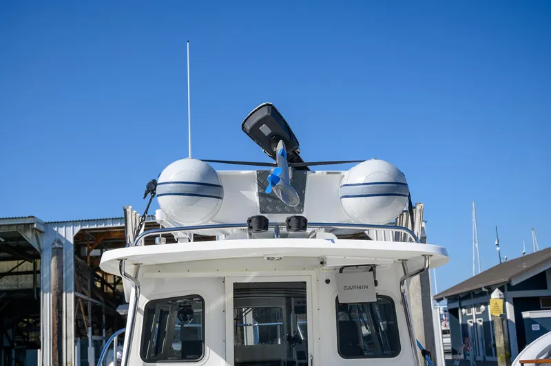 Slide: The Image of 2021 Ocean Sport 26/27 boat with radar and antennas, docked under clear blue sky. - 6