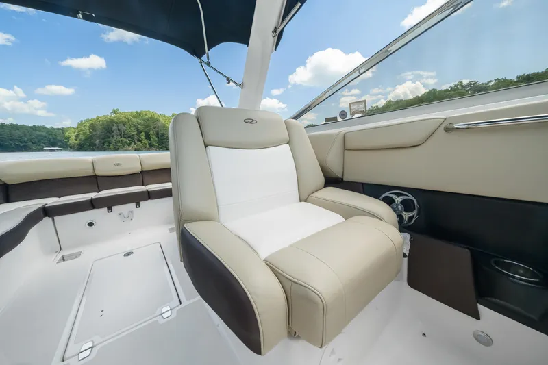 Slide: The Image of 2015 Regal 2700 ES Bowrider interior with beige seating and scenic lake view. - 15