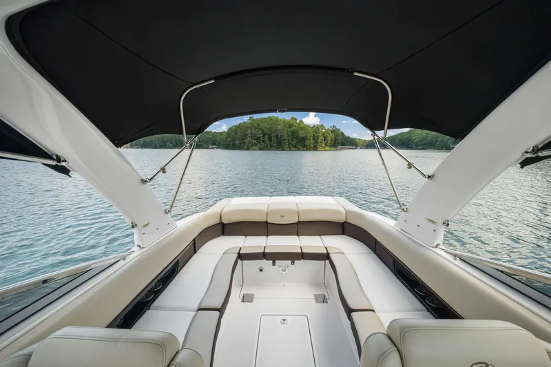 Slide: The Image of 2015 Regal 2700 ES Bowrider interior with lake view, featuring spacious seating and canopy. - 16