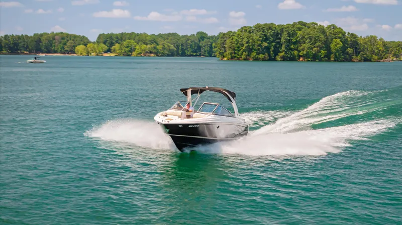Slide: The Image of 2015 Regal 2700 ES Bowrider speeding on a scenic lake with lush green trees. - 4