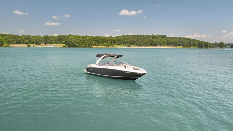 Slide: The Image of 2015 Regal 2700 ES Bowrider on serene lake with lush green shoreline. - 5