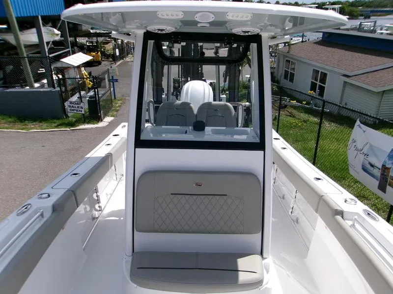 Slide: The Image of 2026 Sportsman Open 232 boat interior with seating and console, docked at a marina. - 13