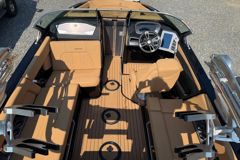 Slide: The Image of 2020 MasterCraft X22 boat interior with tan seating and modern dashboard. - 12