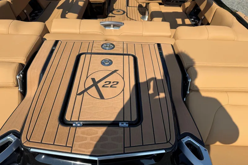 Slide: The Image of 2020 MasterCraft X22 boat interior with tan seating and wood finish deck. - 14