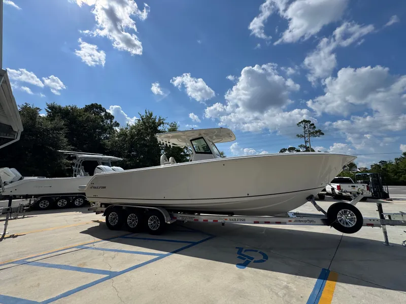 Slide: The Image of 2025 Sailfish 312 CC boat on trailer under blue sky with clouds. - 13
