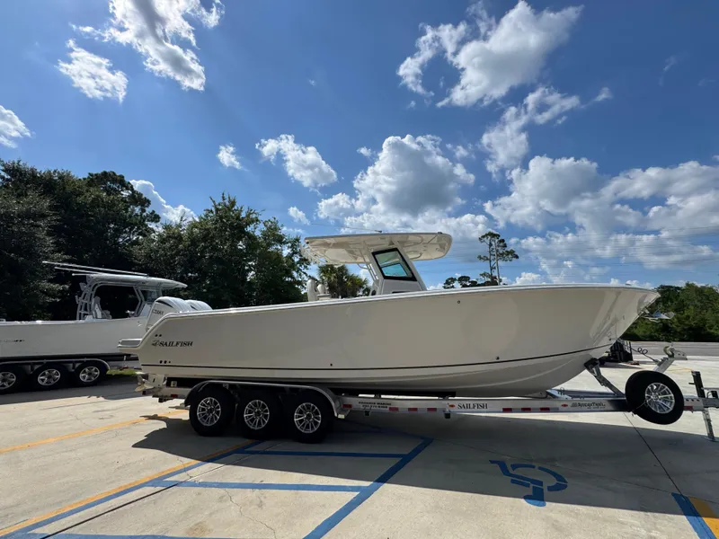 Slide: The Image of 2025 Sailfish 312 CC boat on trailer under blue sky with clouds. - 14