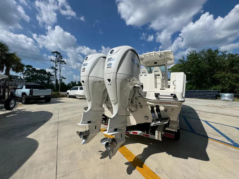 Slide: The Image of 2025 Sailfish 312 CC boat with dual outboard engines, parked outdoors under a blue sky. - 18