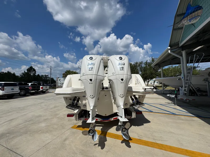 Slide: The Image of 2025 Sailfish 312 CC boat with twin 300 V6 engines, parked outdoors under a blue sky. - 20