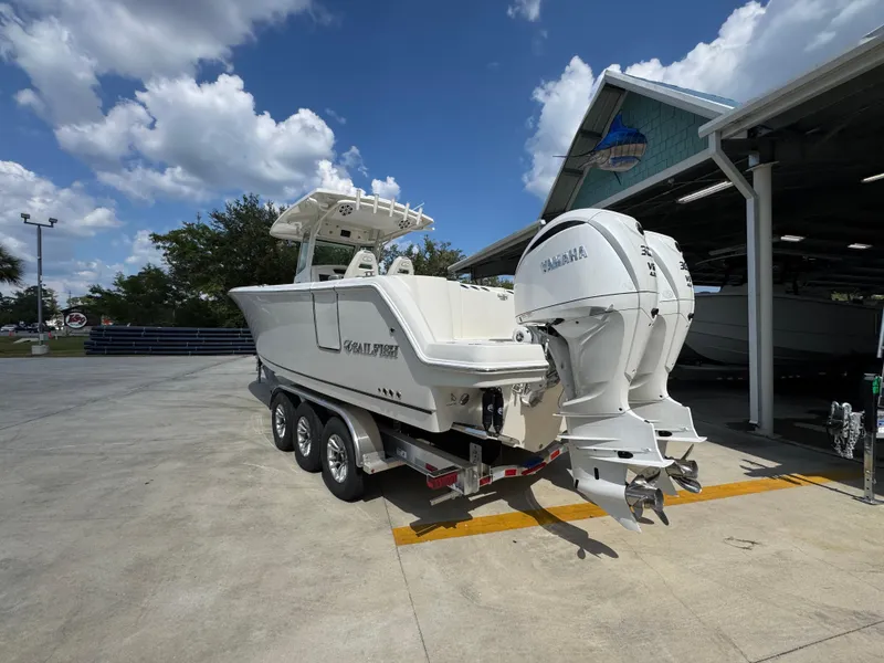 Slide: The Image of 2025 Sailfish 312 CC boat with dual Yamaha engines on a trailer, parked outdoors. - 22