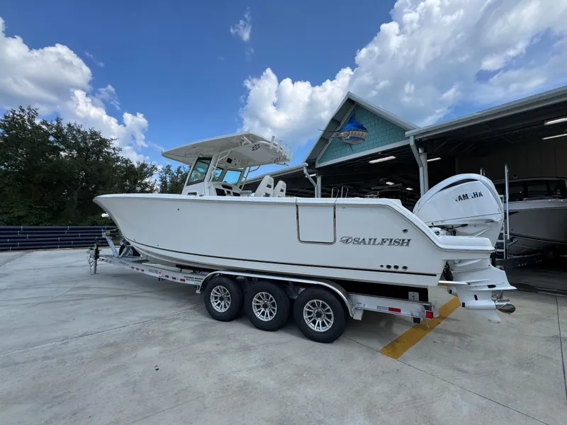 Slide: The Image of 2025 Sailfish 312 CC boat on trailer, parked outdoors under a blue sky. - 24