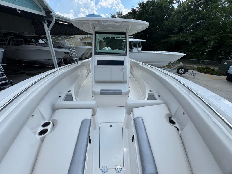 Slide: The Image of 2025 Sailfish 312 CC boat interior with seating and console, docked outdoors. - 30