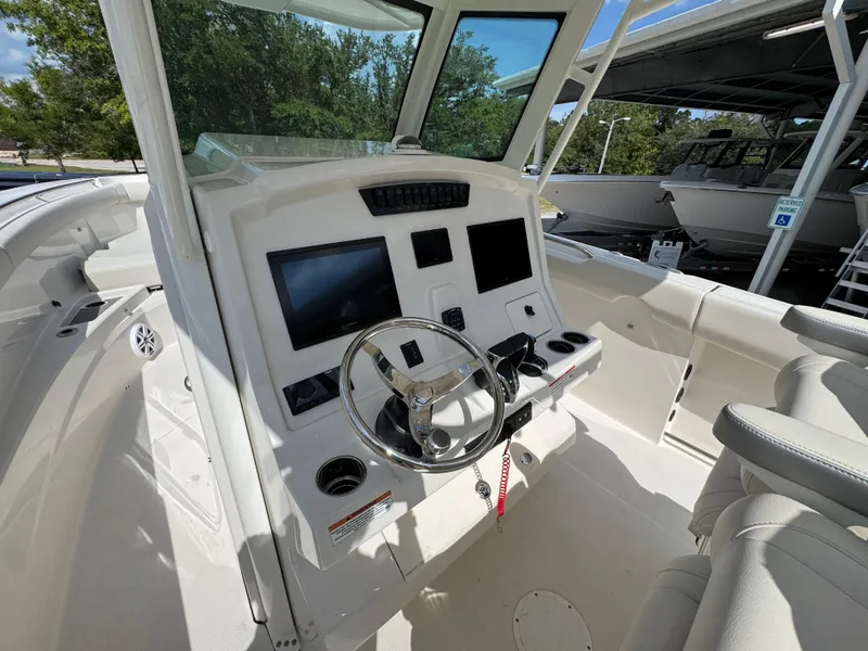 Slide: The Image of 2025 Sailfish 312 CC boat cockpit with steering wheel and digital displays. - 37
