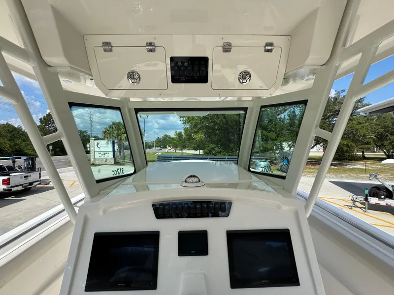Slide: The Image of 2025 Sailfish 312 CC boat dashboard with dual screens and overhead storage. - 39