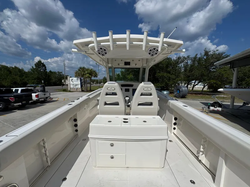 Slide: The Image of 2025 Sailfish 312 CC boat interior with dual seats and storage, under a blue sky. - 41