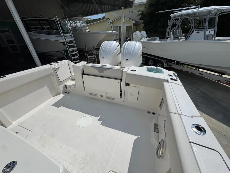 Slide: The Image of 2025 Sailfish 312 CC boat interior with dual engines, docked in a marina. - 44