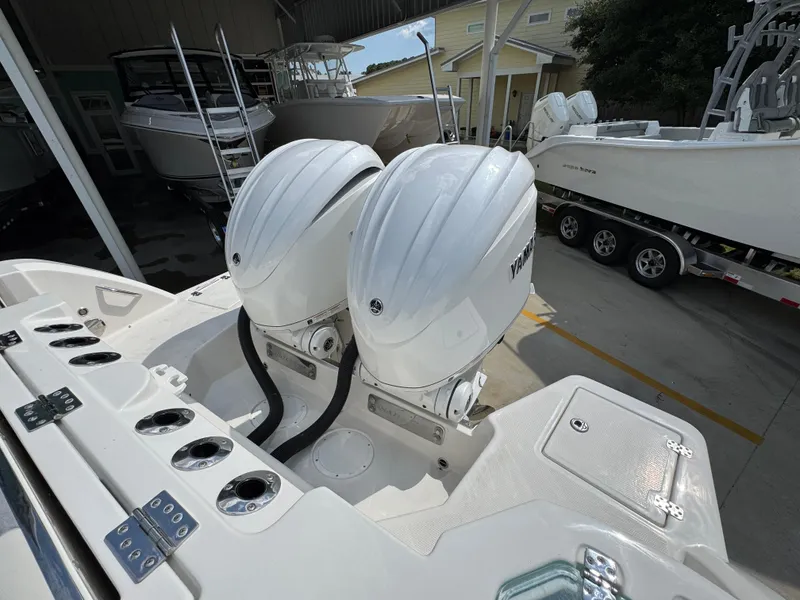 Slide: The Image of 2025 Sailfish 312 CC boat with dual outboard engines in a marina setting. - 47