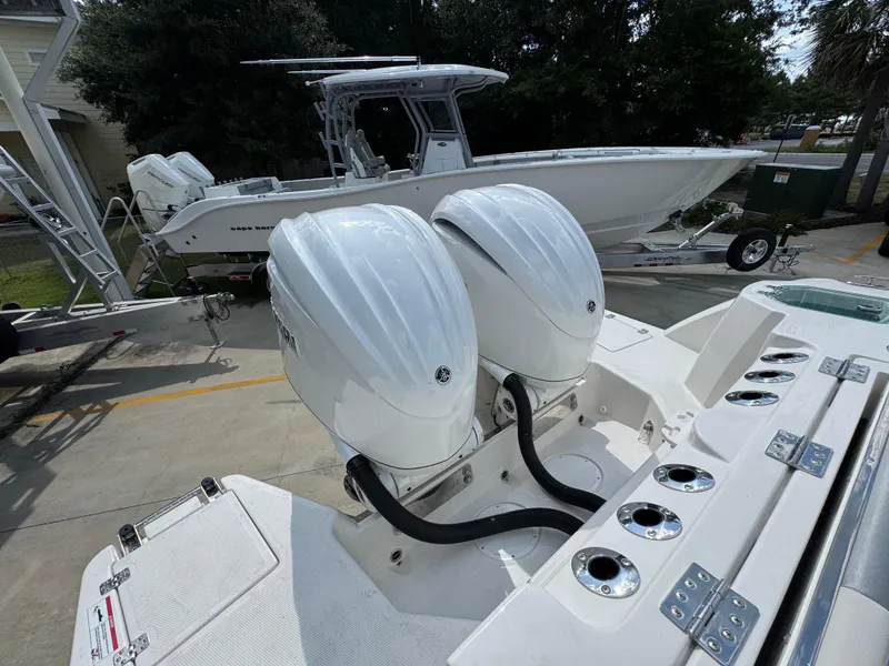 Slide: The Image of 2025 Sailfish 312 CC boat with dual outboard engines, parked on a trailer. - 48