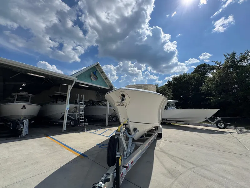 Slide: The Image of 2025 Sailfish 312 CC boat on trailer under a partly cloudy sky. - 7