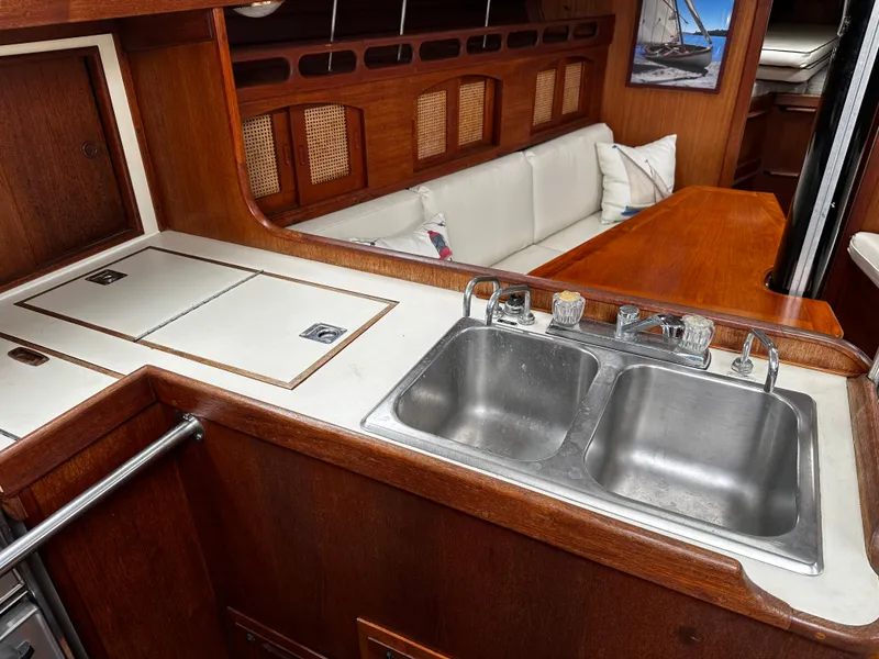Slide: The Image of 1987 Ericson 34 2 yacht interior with wooden cabinetry, dual sink, and cozy seating area. - 11