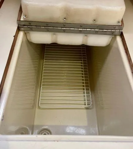 Slide: The Image of 1987 Ericson 34 2 boat cooler with open lid and wire rack inside. - 14