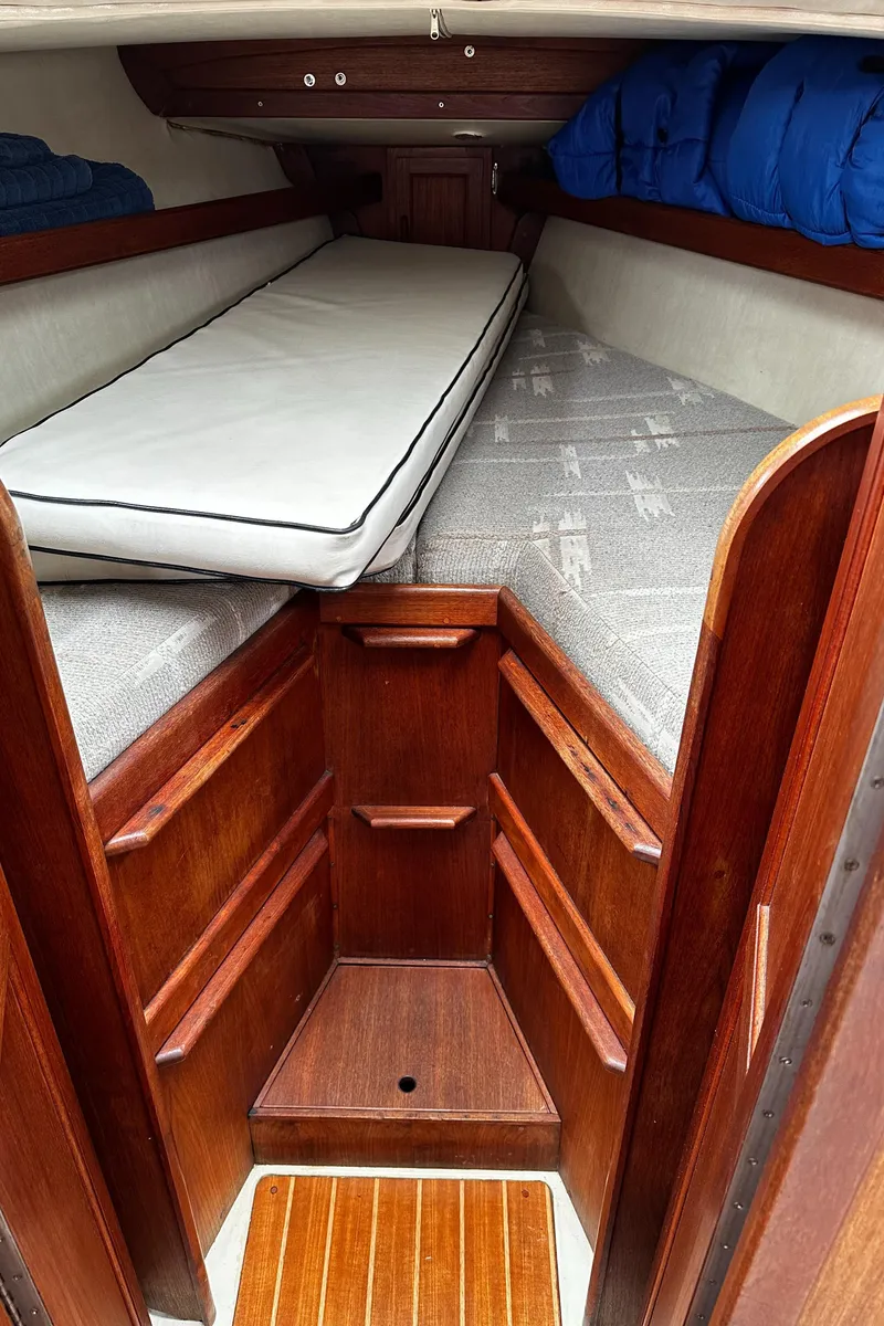 Slide: The Image of Interior cabin of 1987 Ericson 34 2 sailboat with wooden finish and bedding. - 18