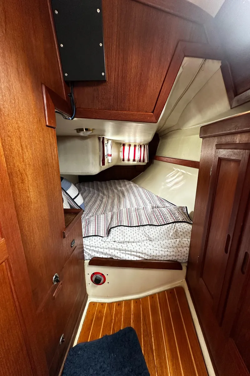 Slide: The Image of Cozy cabin interior of 1987 Ericson 34 2 sailboat with wood paneling and striped bedding. - 20