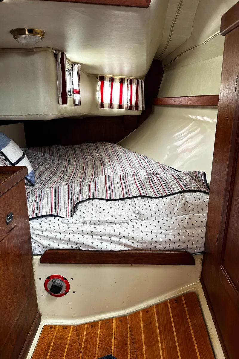 Slide: The Image of Cozy cabin interior of 1987 Ericson 34 2 sailboat with striped bedding and wooden accents. - 21