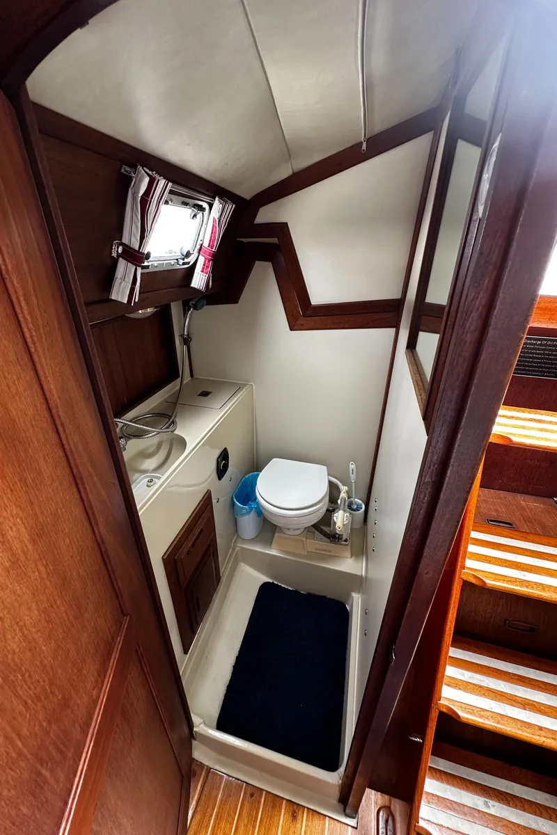 Slide: The Image of 1987 Ericson 34 2 yacht bathroom with sink, toilet, and wooden accents. - 22