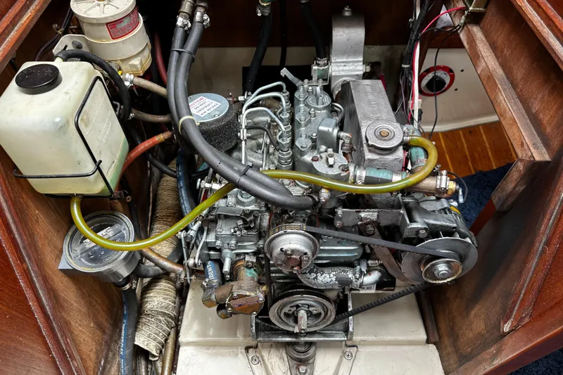 Slide: The Image of Engine compartment of a 1987 Ericson 34 2 sailboat, showcasing mechanical components and wiring. - 24