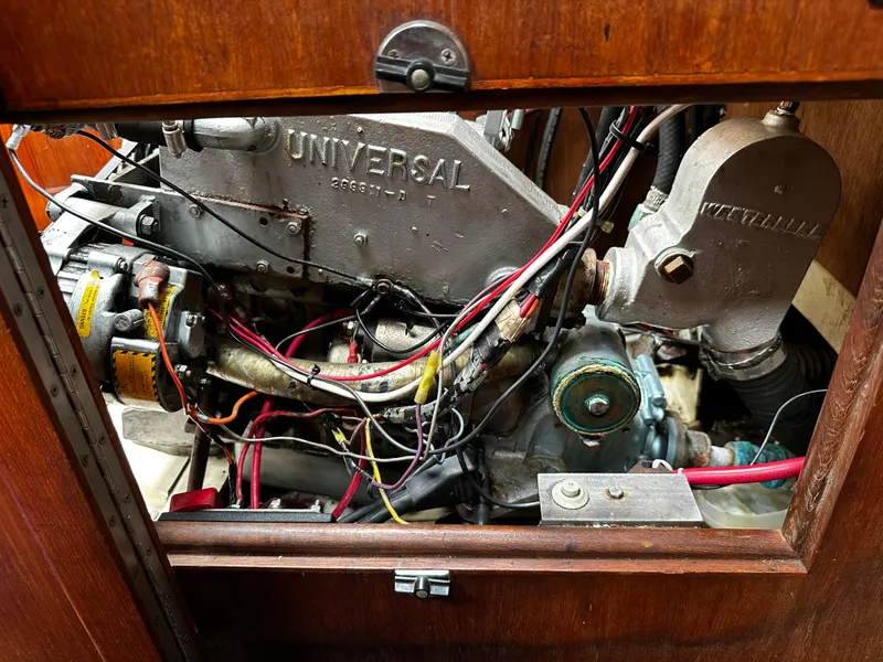Slide: The Image of Engine compartment of a 1987 Ericson 34 2 sailboat, featuring a Universal engine. - 25