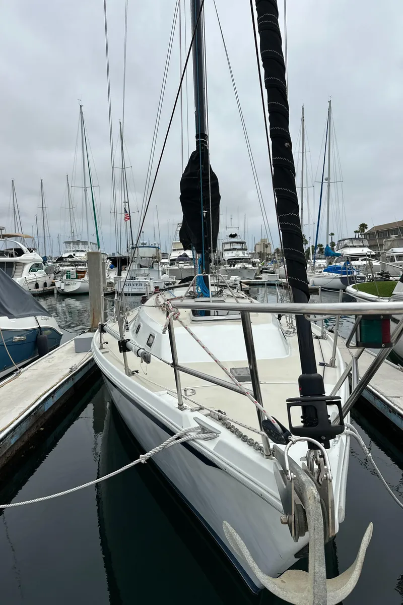 Slide: The Image of 1987 Ericson 34 2 sailboat docked in a marina, surrounded by other boats. - 36
