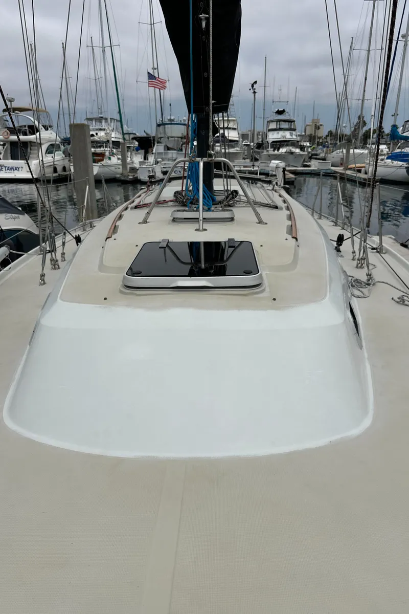 Slide: The Image of 1987 Ericson 34 2 sailboat docked in a marina, featuring a sleek deck design. - 37