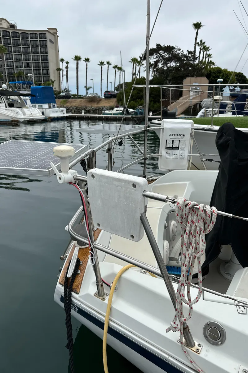 Slide: The Image of 1987 Ericson 34 2 sailboat docked, featuring solar panel and nautical equipment. - 40