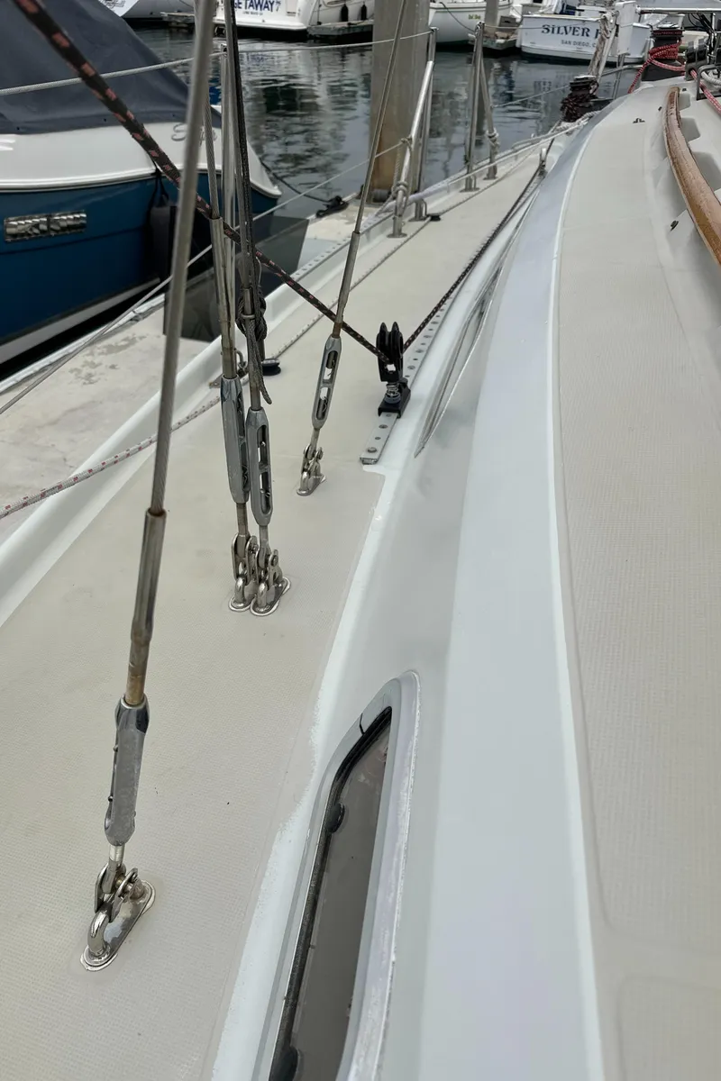 Slide: The Image of 1987 Ericson 34 2 sailboat deck with rigging and docked boats in background. - 44