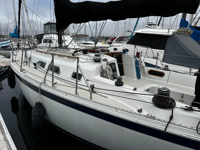 Slide: The Image of 1987 Ericson 34 2 sailboat docked in a marina, featuring a sleek white design. - 46