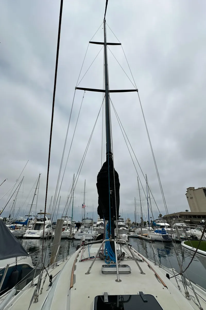 Slide: The Image of Sailboat Ericson 34 2, 1987 model, docked in a marina under cloudy skies. - 48
