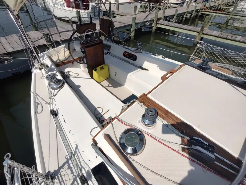 Slide: The Image of 1986 Catalina C-34 sailboat cockpit with steering wheel, winches, and docked at marina. - 13