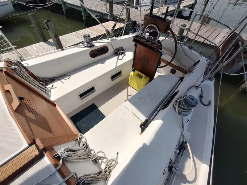 Slide: The Image of 1986 Catalina C-34 sailboat cockpit with ropes, winches, and steering wheel at dock. - 14
