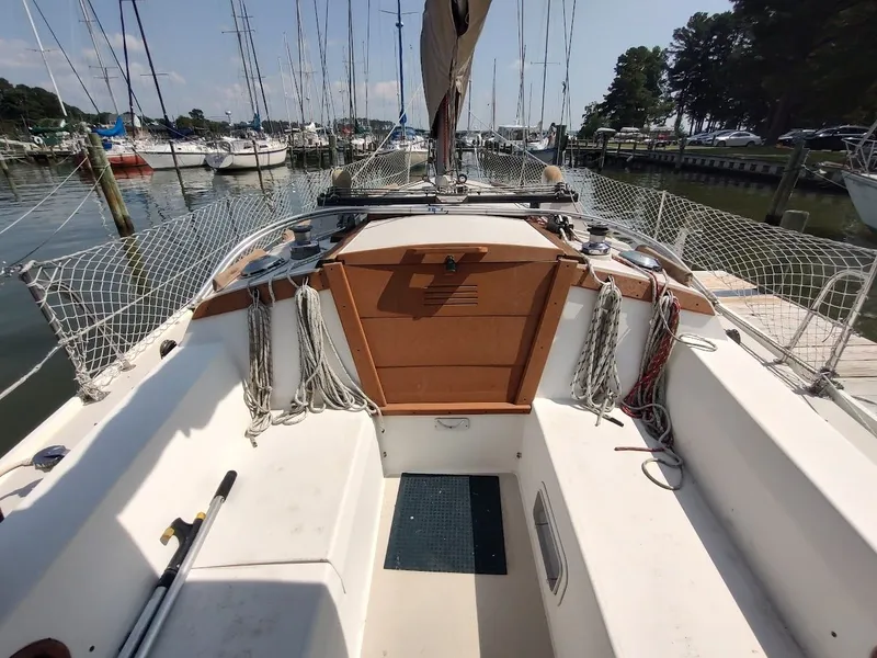 Slide: The Image of 1986 Catalina C-34 sailboat cockpit with ropes and netting, docked in a marina. - 23