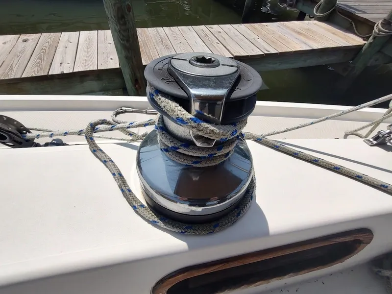 Slide: The Image of Winch with rope on 1986 Catalina C-34 sailboat deck near wooden dock. - 26